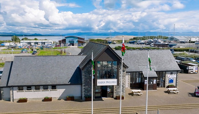 The Hafan Pwllheli building with wales flags outside and mountains in the background