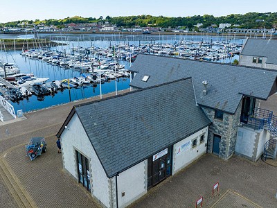 A building with the view of a boatyard in the back
