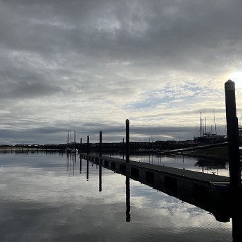 Pontŵn newydd gyda'r haul yn machlud yn y cefndir