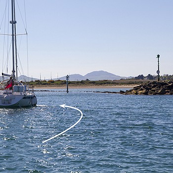 cychod yn y dŵr gyda saeth yn pwyntio at fynedfa'r sianel
